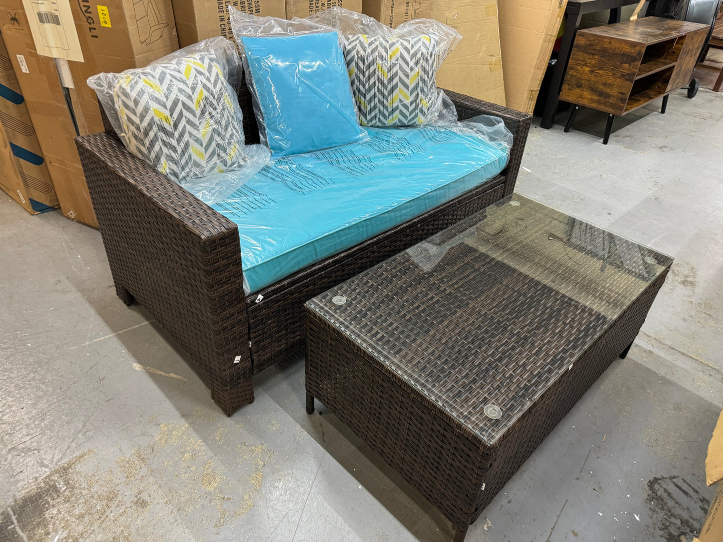 Outdoor Loveseat brown wicker with teal cushion and glass top outdoor table